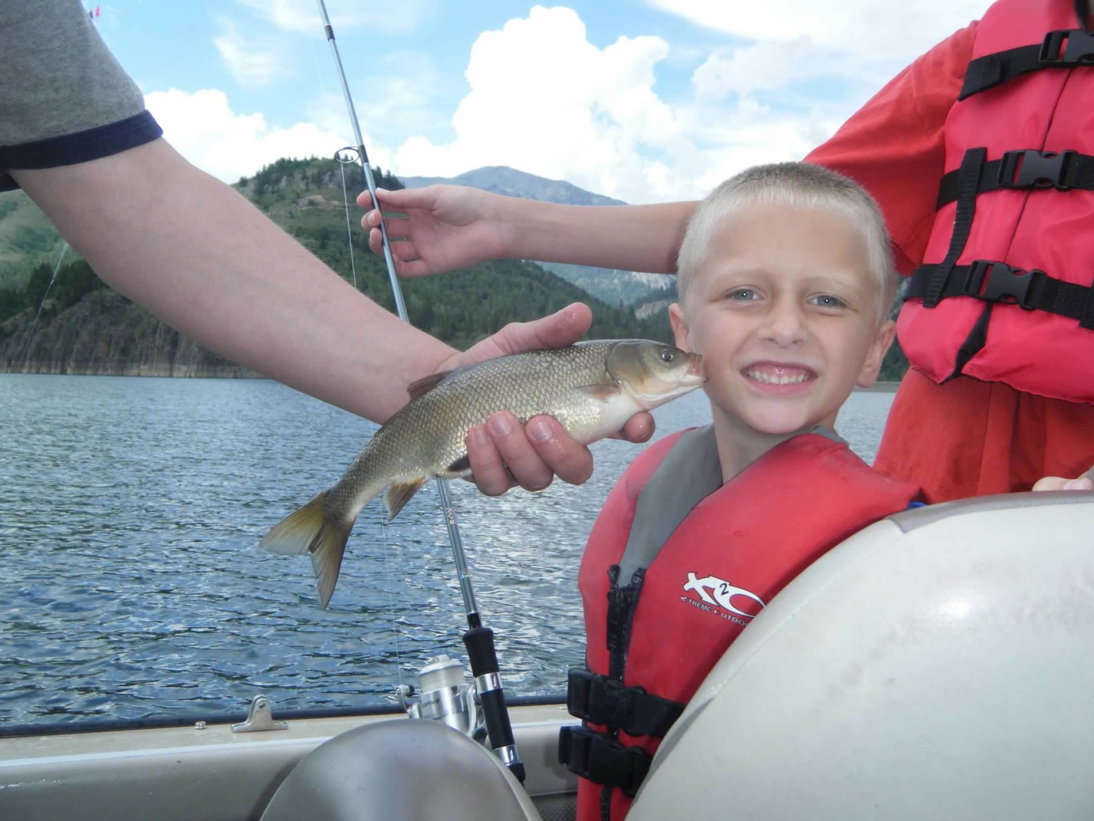 Bryan smiling while his fish kisses him on the cheek.